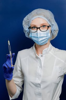 Doktor elinde bir şırınga tutuyor. Aşılama