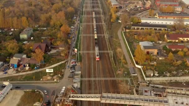 egy külvárosi vonat halad el egy új közúti híd alatt ősszel.