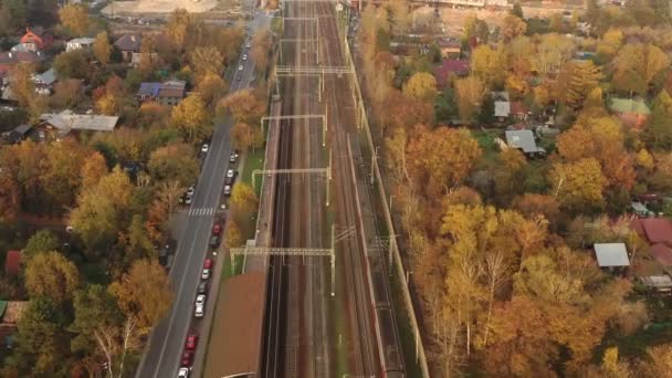 Podmiejski przejazd kolejowy pod nowym mostem drogowym w budowie jesienią. — Wideo stockowe