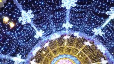 Şehrin sokaklarında aydınlanmalar, insanlar şenlikli sokaklarda yürüyor.