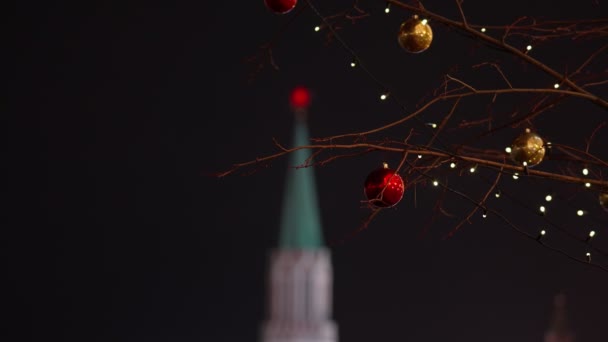 Décorations lumineuses du Nouvel An sur un arbre sur le fond du Kremlin de Moscou la nuit. retiré des mains. 2020 — Video