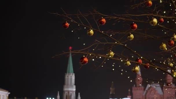 Décorations lumineuses du Nouvel An sur un arbre sur le fond du Kremlin de Moscou la nuit. retiré des mains. 2020 — Video