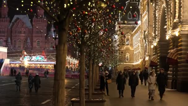 Moscú, Rusia - Diciembre 2020: Iluminación de Año Nuevo en las calles de la ciudad, decoraciones ligeras en el nuevo año, vistas de vacaciones de las calles de la noche. en el dark.ludi caminar por las calles decoradas — Vídeos de Stock