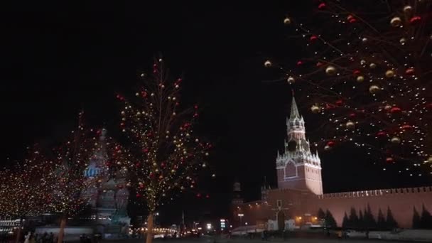 Яркие новогодние украшения на елке на фоне Московского Кремля ночью. снято с рук. 2020 год. Камера-тележка — стоковое видео