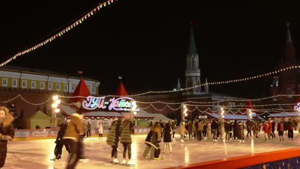 MOSCÚ, RUSIA diciembre, 2020: Los visitantes con máscaras médicas patinan en la pista de patinaje de GUMs Red Square en Moscú durante la pandemia de COVID 19 — Vídeos de Stock