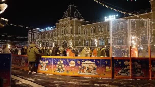 MOSCÚ, RUSIA diciembre, 2020: Los visitantes con máscaras médicas patinan en la pista de patinaje de GUMs Red Square en Moscú durante la pandemia de COVID 19 — Vídeos de Stock
