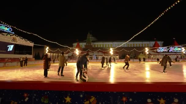 MOSCÚ, RUSIA diciembre, 2020: Los visitantes con máscaras médicas patinan en la pista de patinaje de GUMs Red Square en Moscú durante la pandemia de COVID 19 — Vídeos de Stock