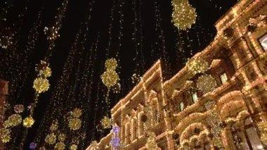 Şehir sokaklarında yeni yıl ışıklandırması, yeni yılda hafif süslemeler, akşam sokaklarının tatil manzarası. Karanlıkta