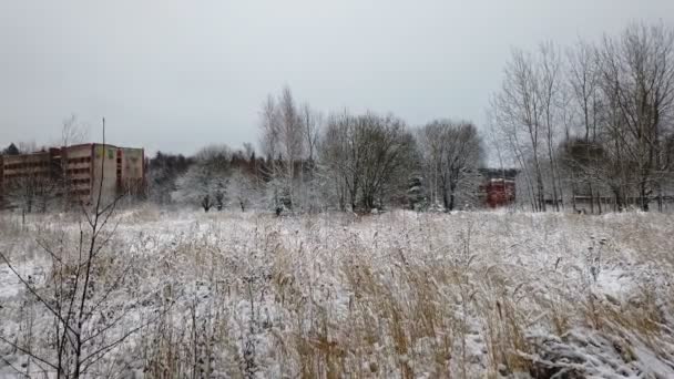 Een verlaten gebouw uit de tijd van de USSR in de winter in een overwoekerde plaats. uit handen genomen — Stockvideo