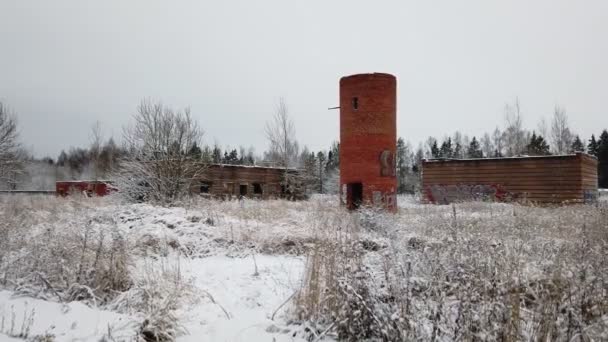 En övergiven byggnad från Sovjetunionens tid på vintern på en övervuxen plats. avlägsnas från händerna — Stockvideo