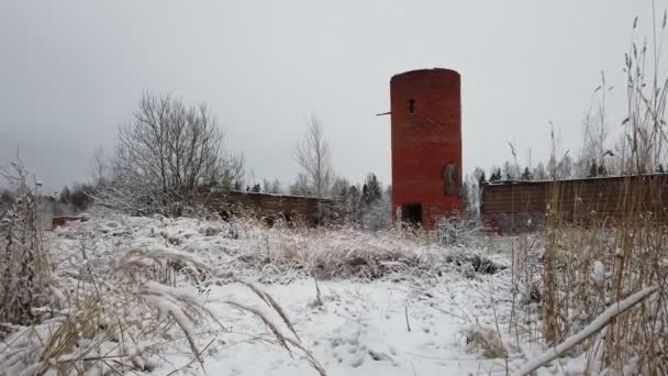 Ένα εγκαταλελειμμένο κτίριο από την εποχή της ΕΣΣΔ το χειμώνα σε ένα κατάφυτο μέρος. αφαιρεθεί από τα χέρια — Αρχείο Βίντεο