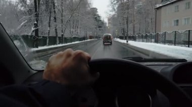 Mans bir banliyö yolunda, kışın karlı bir günde, birinci şahıs manzaralı bir araba sürer. POV