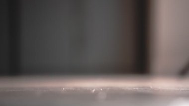 Sarı tekerlekleri salonda yuvarlanan parlak kırmızı bir kaykay. Kapat.