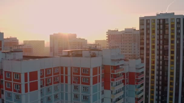 Новый современный жилой комплекс в жилом районе утром на рассвете на фоне яркого солнца зимой. красочные дома. вид с воздуха — стоковое видео