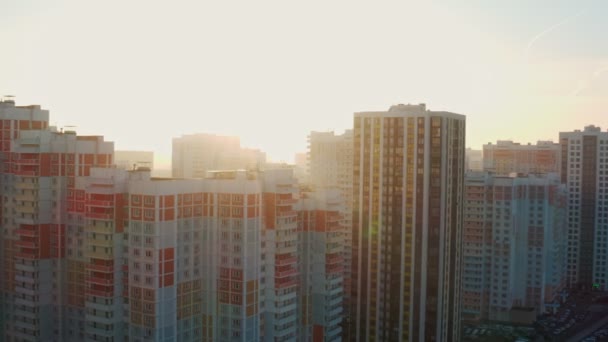 Новый современный жилой комплекс в жилом районе утром на рассвете на фоне яркого солнца зимой. красочные дома. вид с воздуха — стоковое видео