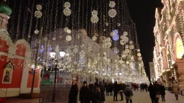 Şehir sokaklarında yeni yıl ışıklandırması, yeni yılda hafif süslemeler, akşam sokaklarının tatil manzarası. Karanlıkta