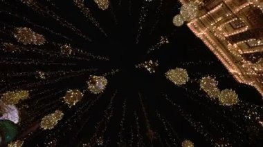 Şehir sokaklarında yeni yıl ışıklandırması, yeni yılda hafif süslemeler, akşam sokaklarının tatil manzarası. Karanlıkta