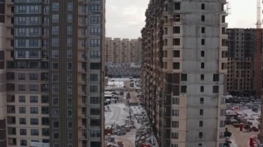 Modern bir bölgenin arka planına karşı kışın yeni modern evler inşa etme süreci en tepede yer alıyor. hava görünümü
