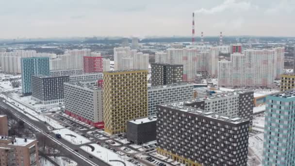 Новые, современные разноцветные многоэтажки на небольшой территории в зимнем ландшафте. вид с воздуха — стоковое видео