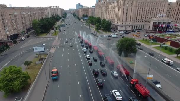Flera speciella vattningsmaskiner, uppradade i rad, vatten en av huvudgatorna i Moskva. Flygbild — Stockvideo