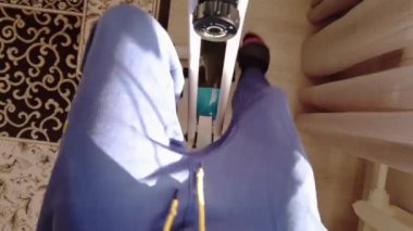 Erkek ayağı evde spor bisikletinin pedallarını çeviriyor. Yukarıdan görünüm