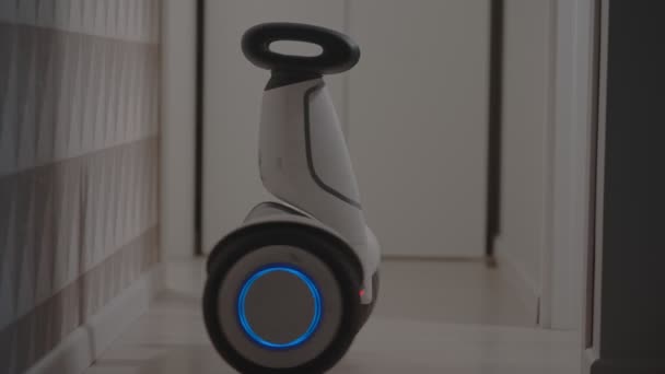 Weiße moderne Gyro-Scooter-Gadget balanciert sich und dreht sich mit Intelligenz, vermeidet Hindernisse im Raum — Stockvideo