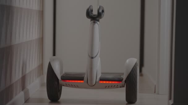 Weiße moderne Gyro-Scooter-Gadget balanciert sich und dreht sich mit Intelligenz, vermeidet Hindernisse im Raum — Stockvideo