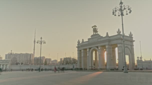 Hlavní vchod na území slavného VDNKh při západu slunce na začátku jara, mnoho lidí v časovém odstupu — Stock video