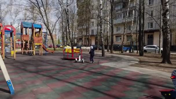 Bambino divertente giocare sul parco giochi con l'aiuto di nuove tecnologie gadget segway all'inizio della primavera — Video Stock