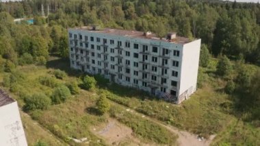 SSCB zamanından kalma terk edilmiş ve yıkılmış binaların yeşil renkli manzaralı bir yaz manzarası.