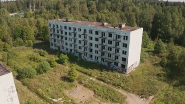 Letecký pohled na opuštěné a zničené budovy z dob SSSR v zeleném malebném místě v létě — Stock video