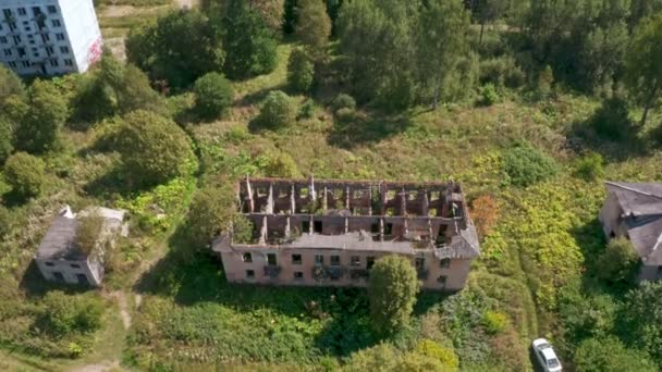 Aerial view of abandoned and destroyed buildings from the times of the USSR in a green picturesque place in summer — Stock Video