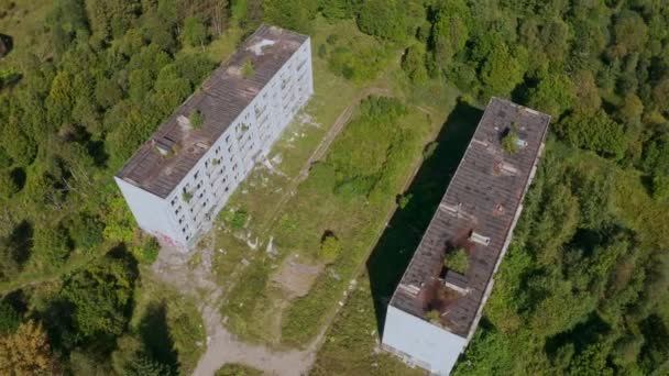 Luchtfoto van verlaten en vernielde gebouwen uit de tijd van de USSR op een groene schilderachtige plek in de zomer — Stockvideo