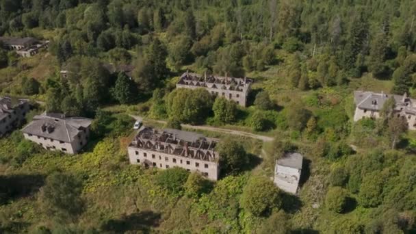 Αεροφωτογραφία εγκαταλελειμμένων και κατεστραμμένων κτιρίων από την εποχή της ΕΣΣΔ σε ένα καταπράσινο γραφικό μέρος το καλοκαίρι — Αρχείο Βίντεο