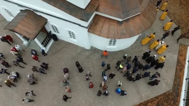 Procession religieuse autour de l'église par les prêtres pendant la fête orthodoxe, dans un endroit pittoresque sur fond de paysage en automne doré — Video