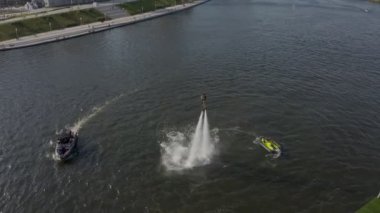 Bir kızla birlikte uçan bir kaykayla nehrin üzerinden uçan bir adam suya dalıyor. Uçuş sörfü yeni bir ekstrem su sporu. Bir adam uçarken numaralar yapar. Olağanüstü spor darbeleri ve dönüşleri.. 