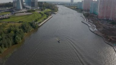 Motorlu tekne yazın pitoresk bir şehir manzarasında nehir boyunca gider. Kuşgözü.