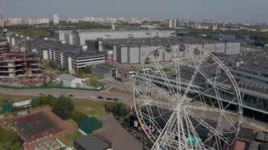 Modern bir metropolün arka planına karşı dönme dolap. Kuşgözü.