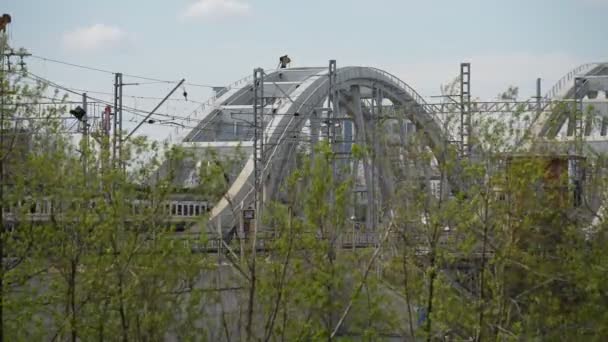 Tren eléctrico moderno suburbano paseos a través del puente en un lugar pintoresco de la metrópoli en el verano — Vídeo de stock