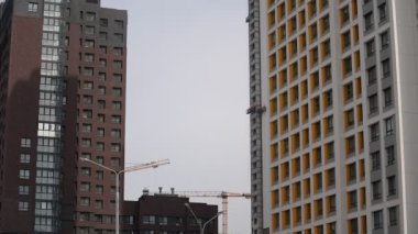 Yüksek binalar inşa edenler beşikteki bir yükseklikte modern bir ev inşa ediyorlar. Yüksek irtifa tırmanışçıları bir inşaat beşiğinde yükseklerde.