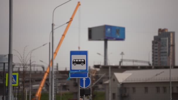 Przystanek autobusowy znak drogowy, na tle nowoczesnej metropolii — Wideo stockowe