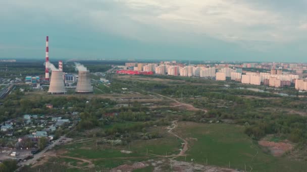 Kombinovaná tepelná a elektrárna při západu slunce. v sousedství města. - Ano. letecký pohled. Obecný plán. — Stock video