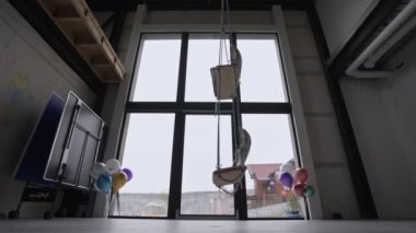 Bitmemiş panoramik pencereli bir evde boş bir salıncak sallanıyor