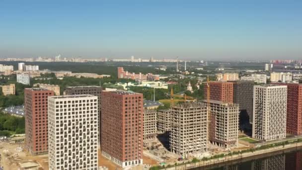 Nieuw modern gebied gebouwd. Bakstenen moderne gebouwen met meerdere verdiepingen aan de oever van de rivier de Moskva. reflectie van huizen in de rivier. vanuit de lucht bekeken — Stockvideo