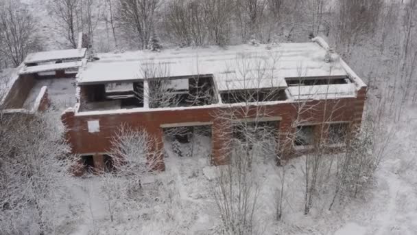 Un edificio abandonado de los tiempos de la URSS en invierno en un lugar cubierto de vegetación. extraño paisaje — Vídeos de Stock