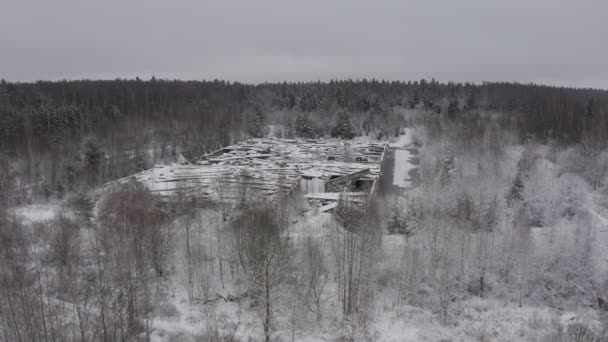 En förstörd byggnad som efter kriget, mitt i ett skogslandskap på vintern. Flygbild. ruiner på vintern — Stockvideo