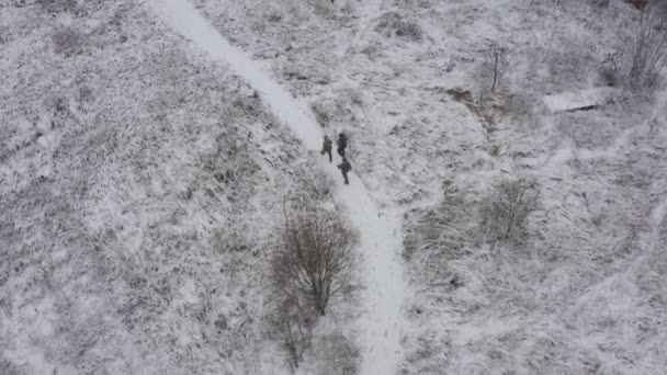 Troje żołnierzy w pełnych mundurach udaje się zimą do miejsc działań wojennych. widok z powietrza — Wideo stockowe