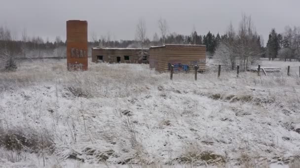 Un edificio abandonado de los tiempos de la URSS en invierno en un lugar cubierto de vegetación. extraño paisaje — Vídeos de Stock