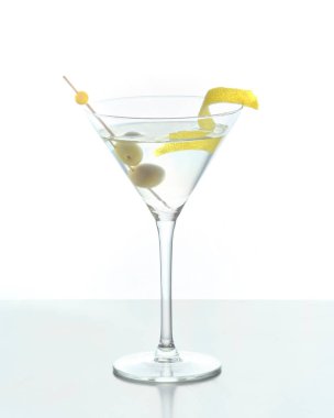 Limon kabuğuyla karıştırılmış martini ve beyaz arka planda zeytin.