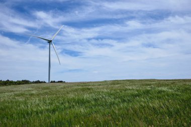 Güzel güneşli yaz manzaralarında bulutlu rüzgar türbinleri. Ekolojik enerji üretimi. Rüzgar tarlasının ekolojik alanı.